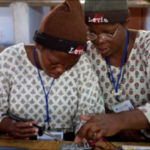 Women working on solar lighting circuit boards.